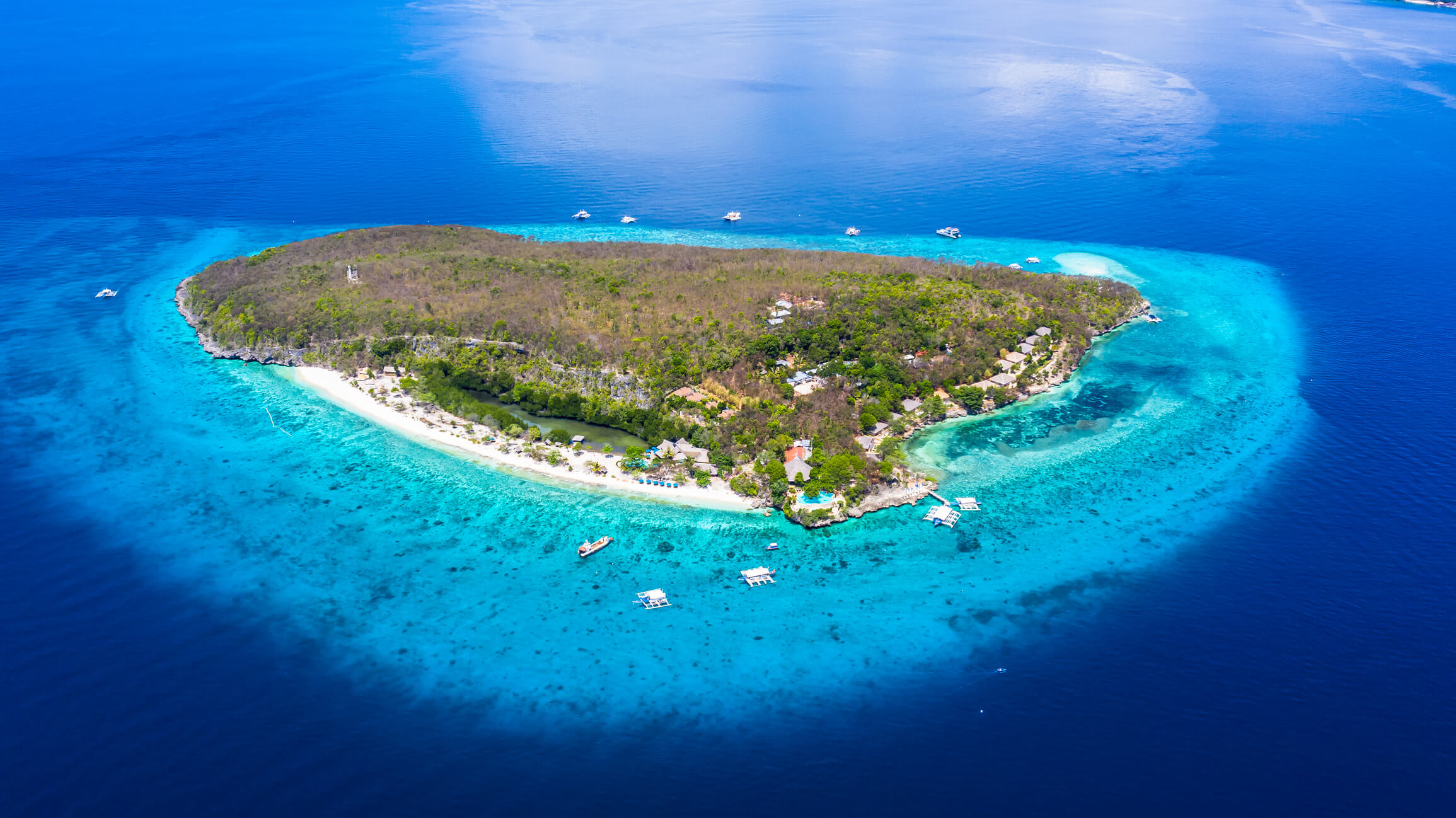 Aerial view of the Sumilon island, sandy beach with tourists swimming in beautiful clear sea water of the Sumilon island beach